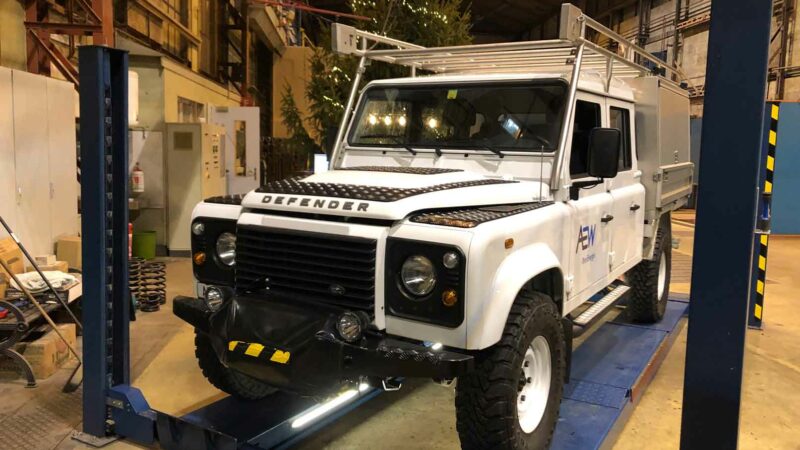 Land Rover Defender 130 als Arbeitsfahrzeug mit Dachträger, Seilwinde, Trittbrettern und Ladeflächen-Aufbau