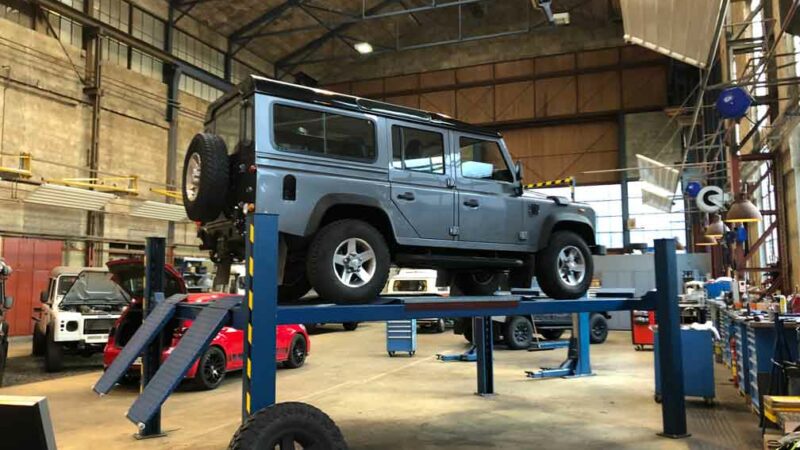 Land Rover Defender auf dem angehobenen Werkstatt-Lift bei der TravelTech GmbH